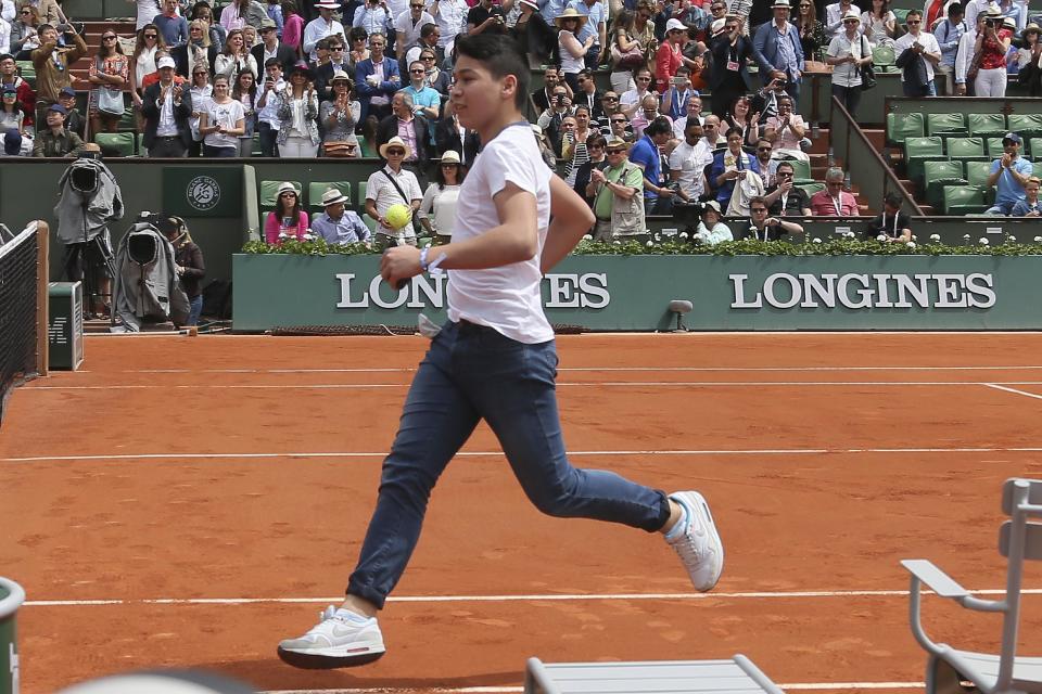 A boy who climbed down from the stands runs to get a selfie with Switzerland's Roger Federer Sunday was allowed far too much time to get the job done. (AP Photo/David Vincent)