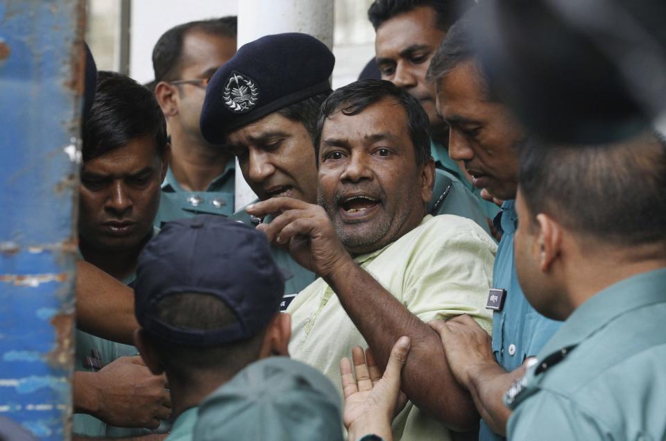 A prisoner reacts as police force him into a van after the verdict for a 2009 mutiny is announced, in Dhaka