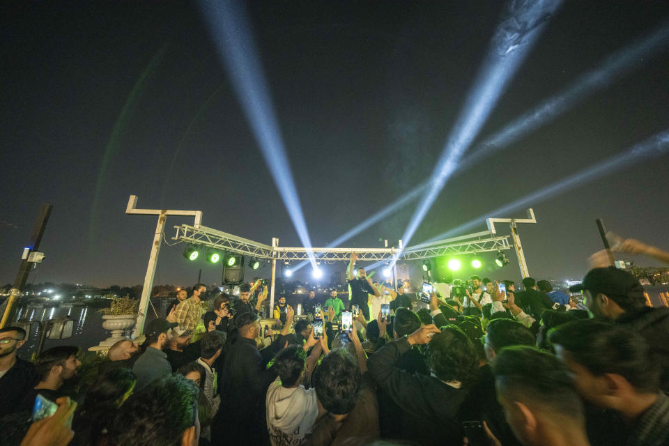 Youths gather along the Tigris River for a concert by rap artist Khalifa OG in Baghdad, Iraq, Saturday Feb. 25, 2023. In his music, he sings about the difficulties of finding work and satirizes authority, but is not blatantly political. (AP Photo/Jerome Delay)