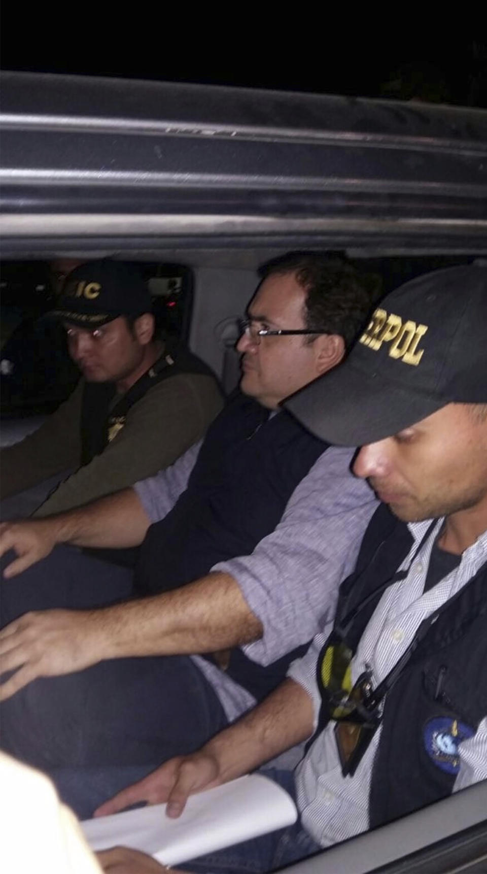 En esta fotografía difundida por la Policía Nacional Civil de Guatemala, agentes escoltan a Javier Duarte, exgobernador del estado mexicano de Veracruz que estaba prófugo, al centro, dentro de un automóvil en Panajachel, Guatemala, el sábado 15 de abril de 2017. Duarte, acusado de corrupción, fue detenido en Guatemala el sábado. (Policía Nacional Civil de Guatemala vía AP)