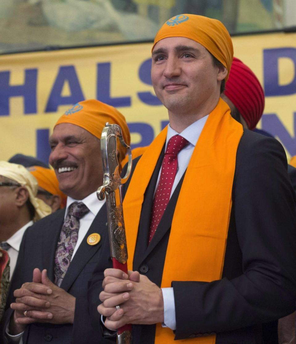 Members of the Sikh Caucus surround Prime Minister Justin Trudeau after he was presented with a sword during a Vaisakhi Celebration on Parliament Hill in Ottawa, Monday, April 11, 2016. THE CANADIAN PRESS/Adrian Wyld