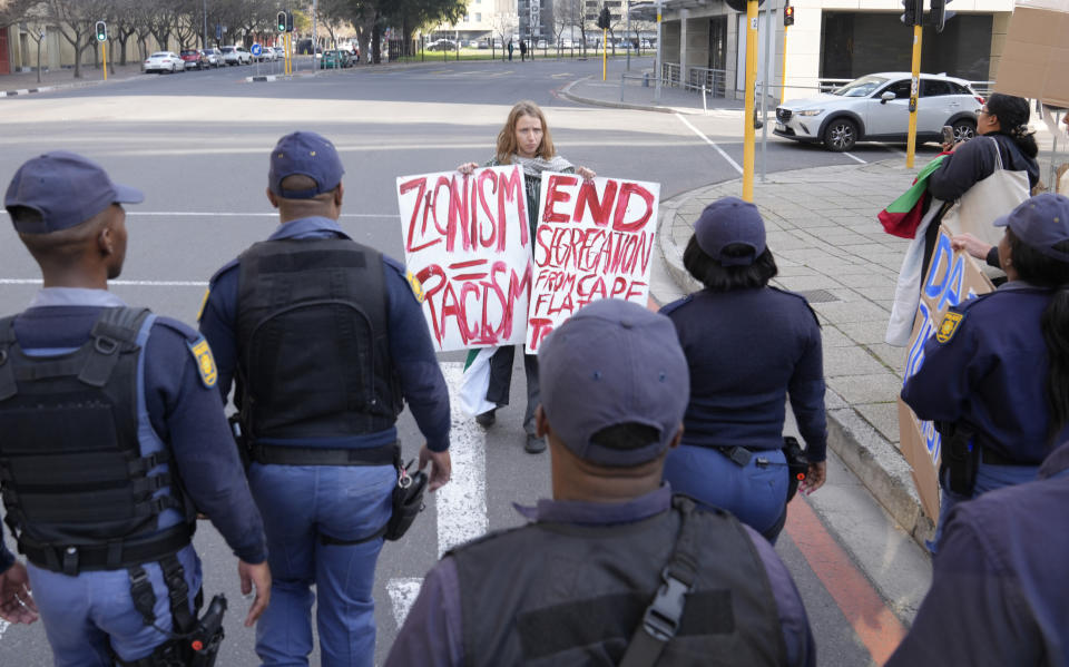 A protester carries placards in support of Palestinians in Cape Town, South Africa, Friday June 14, 2024 as Parliament sits for the first time since general elections last month. South African President Cyril Ramaphosa was expected to be reelected for a second term Friday after his African National Congress party signed a last-minute coalition agreement with its long-time political rival during the first sitting of the new Parliament. (AP Photo/Nardus Engelbrecht)