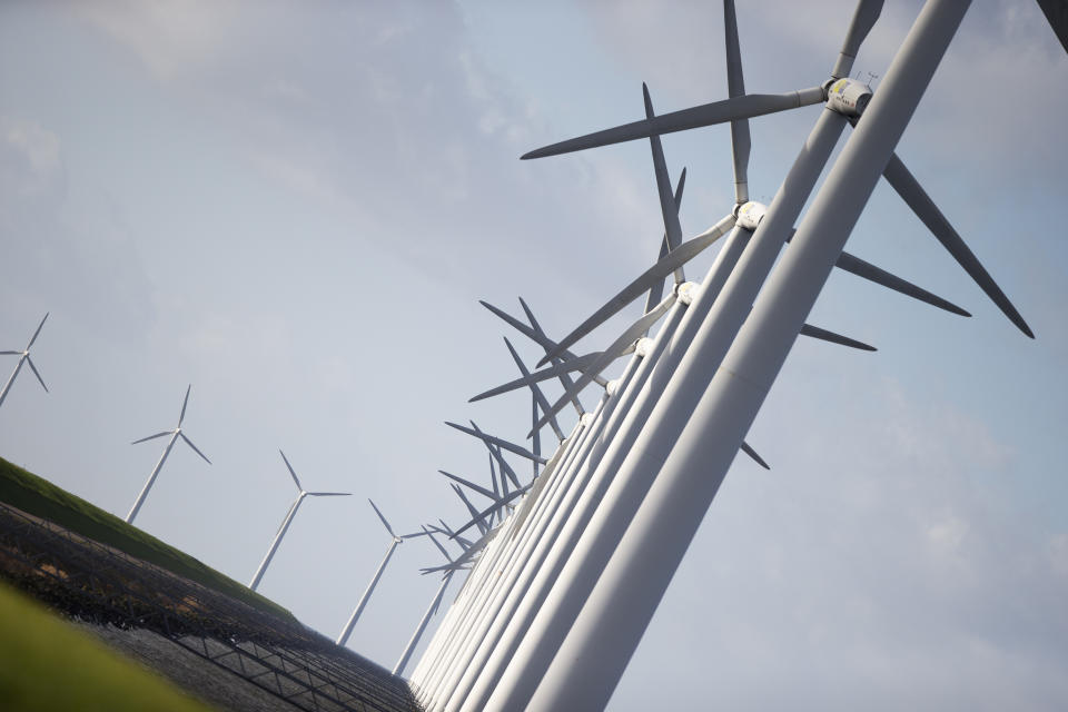 Wind turbines are seen on a dike near Urk, Netherlands, Friday, Jan. 22, 2021. A group of scientists, including five Nobel laureates, called Friday for more action to adapt the world to the effects of climate change, drawing comparisons with the faltering response to the coronavirus crisis, ahead of a major online conference on climate adaptation starting Monday and hosted by the Netherlands. (AP Photo/Peter Dejong)