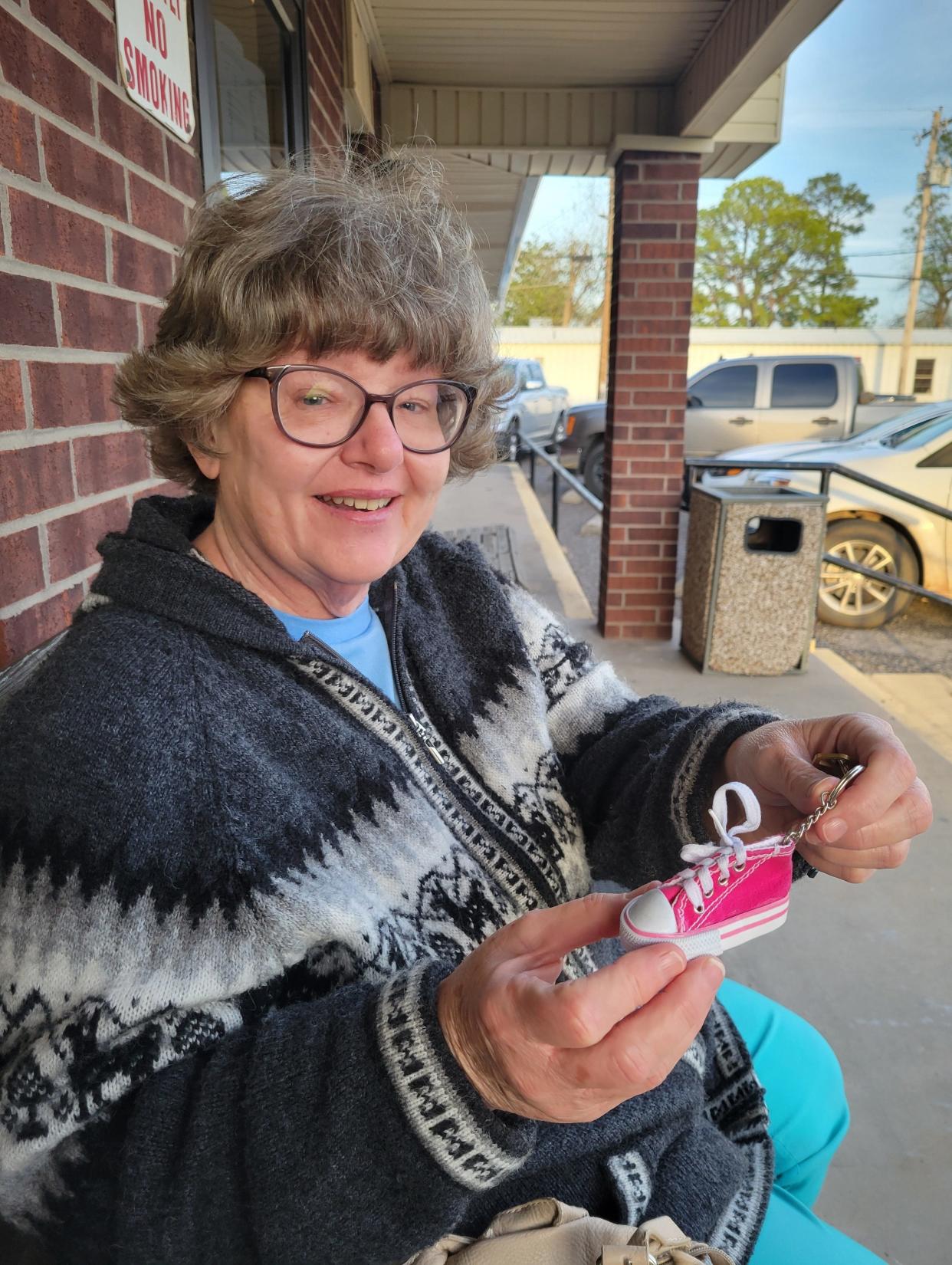 Lisa Rollings on April 12 holds up the key chain she won in a dance contest at the 2023 Footloose Festival in Elmore City, Oklahoma. The 1984 movie "Footloose," released 40 years ago this year, is based on the successful efforts of Elmore City High School students to organize the school's first prom in 1980. Rollings attended the first prom as a sophomore server, and she went on to help launch Elmore City's annual Footloose Fest, which takes place the third Saturday of April.