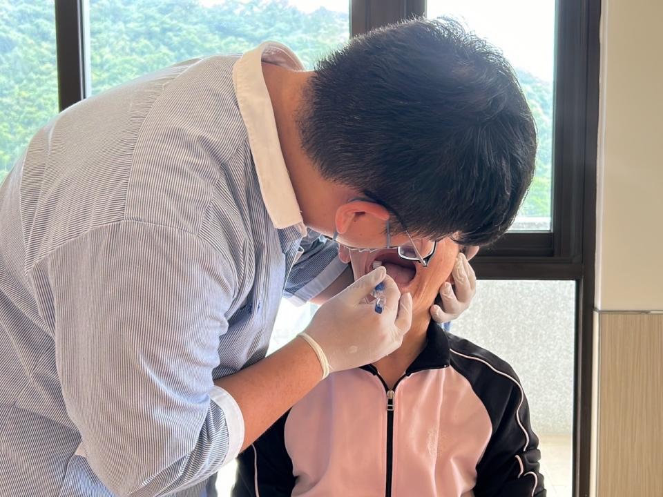 學生楊承諺為住民進行口腔清潔。圖：新生醫專提供