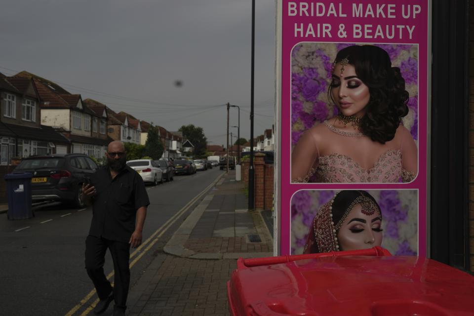 A man walks past a cosmetic shop in the district of Southall in London, Tuesday, Sept. 13, 2022. In a church in a West London district known locally as Little India, a book of condolence for Queen Elizabeth II lies open. Five days after the monarch’s passing, few have signed their names. The congregation of 300 is made up largely of the South Asian diaspora, like the majority of the estimated 70,000 people living in the district of Southall, a community tucked away in London's outer reaches of London and built on waves of migration that span 100 years. (AP Photo/Kin Cheung)