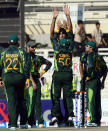 Pakistani bowler Mohammad Irfan (C) celebrates with teammates after taking a wicket off South African batsman Hashim Amla (unseen) during the fifth and final one-day at Sharjah Cricket Stadium in Sharjah on November 11, 2013. South Africa lead the five-match series 3-1. AFP PHOTO/Asif HASSAN