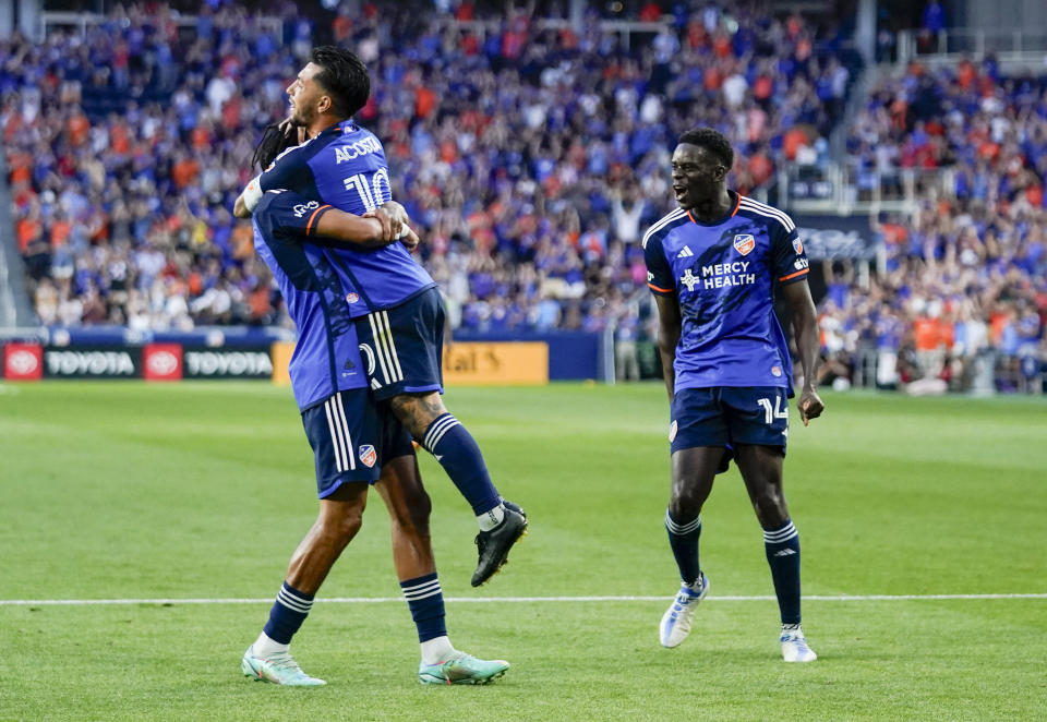 FC Cincinnati's Luciano Acosta (10) celebrates with Marco Angulo and Dominique Badji (14) after scoring a goal against Toronto FC during the second half of an MLS soccer match Wednesday, June 21, 2023, in Cincinnati. (AP Photo/Jeff Dean)