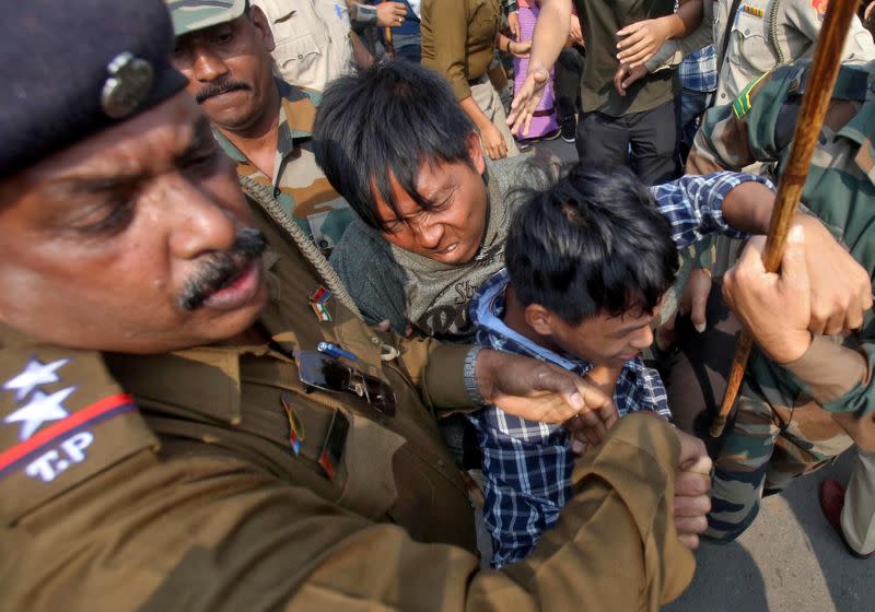 Police officers try to detain demonstrators during a protest against the Citizenship Amendment Bill, in Agartala