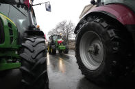 Farmers driving in a heavy-duty tractor into the western city of Poznan as part of a nationwide farmer protest against European Union's agrarian policy and imports of cheap Ukraine produce, which, they say, are undercutting their livelihoods, in Poznan, Poland, on Friday Feb. 9, 2024. (AP Photo/Czarek Sokolowski)