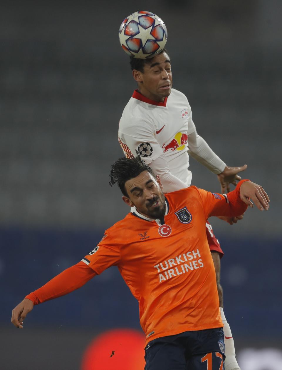 Leipzig's Tyler Adams, background, and Basaksehir's Irfan Can Kahveci jump for the ball during the Champions League group H soccer match between Istanbul Basaksehir and RB Leipzig at Fatih Terim Stadium in Istanbul, Wednesday, Dec. 2, 2020. (AP Photo)