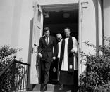 FILE - In this March 10, 1963 file photo, President John F. Kennedy leaves St. John's Episcopal Church after attending Mass at St. Stephens Roman Catholic Church in Washington. At right is Rev. John C. Harper, new rector of the church, and at rear is the Right Rev. William F. Creighton, Episcopal Bishop of Washington. During his visit to St. John's, Kennedy signed a prayer book which bears the signatures of all presidents since Herbert Hoover. (AP Photo)