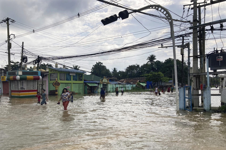 Local residents wade through a flooded road in Bago, Myanmar, about 80 kilometers (50 miles) northeast of Yangon, Friday, Aug. 11, 2023. (AP Photo)