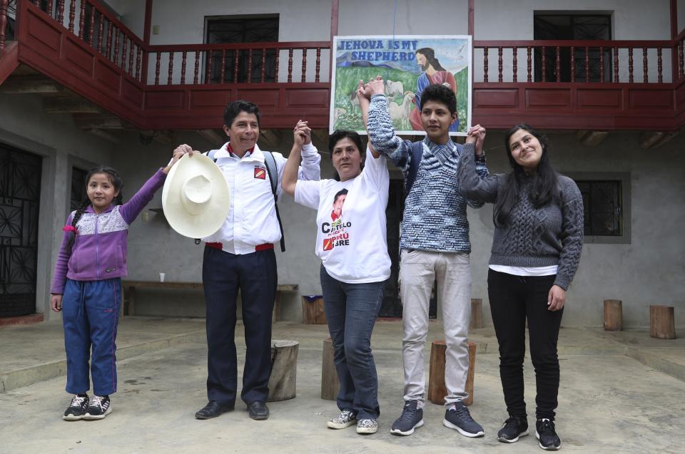 Free Peru party presidential candidate Pedro Castillo, second from left, poses for a photo with his family, from left, daughter Alondra 9, son Arnold 16, wife Lilia Paredes, and sister-in-law Yenifer Paredes, before leaving their home to campaign in Chugur, Peru, Friday, April 16, 2021. Castillo, a rural teacher, who has proposed rewriting Peru's constitution and deporting all immigrants living in the country illegally who commit crimes, will face rival candidate Keiko Fujimori in the June 6 presidential run-off election. (AP Photo/Martin Mejia)