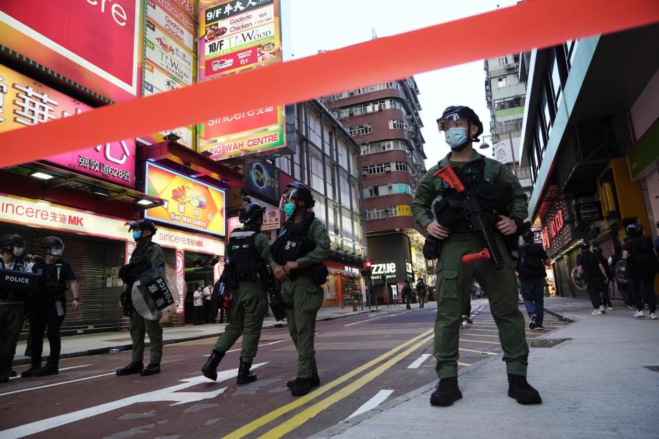 Police officers stand guard at a downtown street in Hong Kong Sunday, Sept. 6, 2020. About 30 people were arrested Sunday at protests against the government's decision to postpone elections for Hong Kong's legislature, police and a news report said. (AP Photo/Vincent Yu)