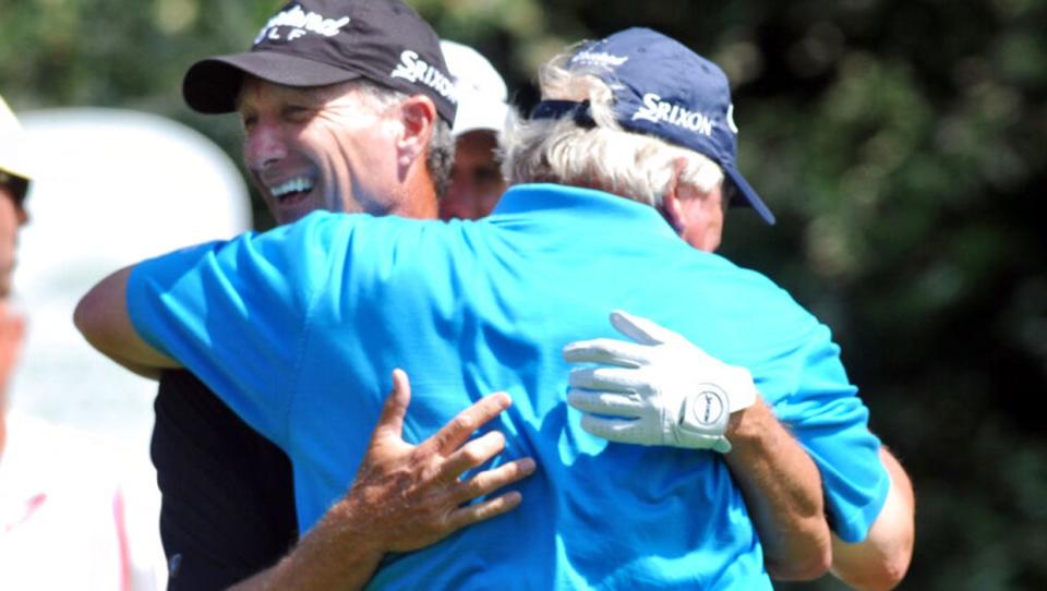 Gary Koch gets a hug from his partner Roger Maltbie after hitting a good tee shot on the 15th hole on Friday, April, 20, 2012, during the first round of the Champions Tour golf tournament at the Club at Savannah Harbor in Savannah, Ga. (AP Photo/Savannah Morning News, Richard Burkhart)  THE EXAMINER.COM OUT; SFEXAMINER.COM OUT; WASHINGTONEXAMINER.COM OUT
