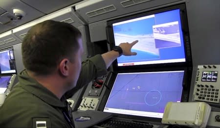 A U.S. Navy crewman aboard a P-8A Poseidon surveillance aircraft views a computer screen purportedly showing Chinese construction on the reclaimed land of Fiery Cross Reef in the disputed Spratly Islands May 21, 2015. REUTERS/U.S. Navy/Handout via Reuters