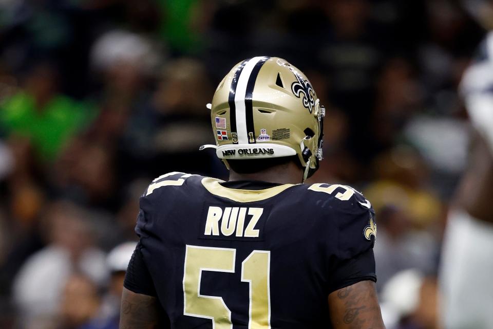 New Orleans Saints center Cesar Ruiz wears an international flag decal and a Crucial Catch logo on his helmet during an NFL football game against the Seattle Seahawks.