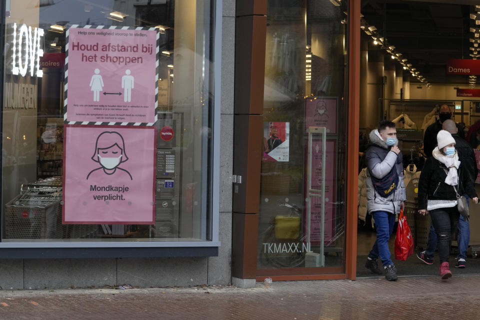 Signs warn shoppers of mandatory face mask and the need to respect social distancing in Nijmegen, eastern Netherlands, Sunday, Nov. 28, 2021. The Dutch government tightened its lockdown Friday Nov. 26, to go into effect Sunday 5 pm amid swiftly rising infections and ICU admissions. (AP Photo/Peter Dejong)