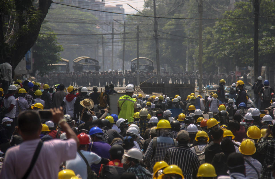 Anti-coup protesters, behind makeshift barricades stand off with Myanmar security forces in Yangon, Myanmar, Tuesday, March 2, 2021. Police in Myanmar repeatedly used tear gas and rubber bullets Tuesday against crowds protesting last month's coup, but the demonstrators regrouped after each volley and tried to defend themselves with barricades as standoffs between protesters and security forces intensified. (AP Photo)