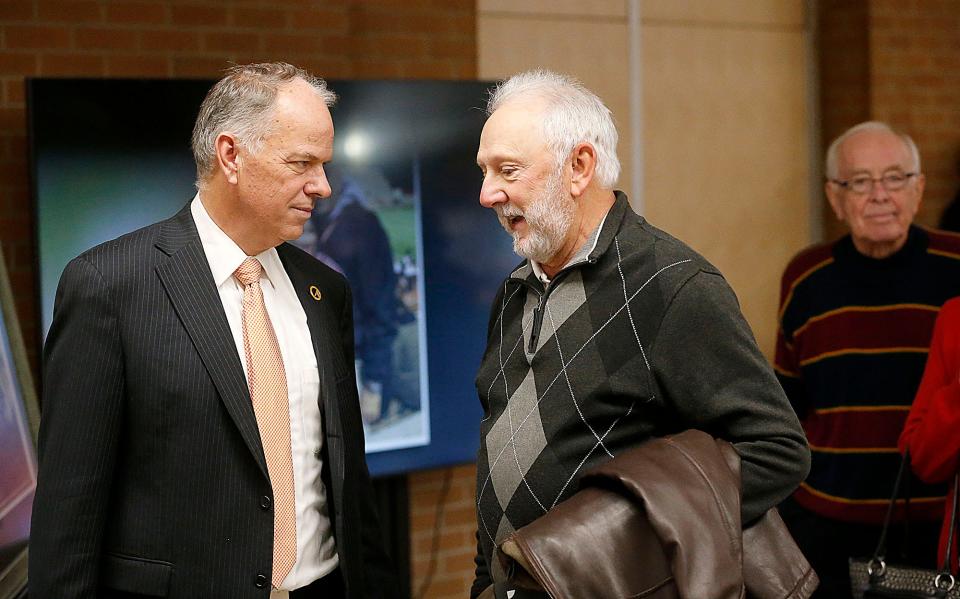 Ashland City Schools Superintendent Doug Marrah talks with Dwight McElfresh on Dec. 12, during a reception honoring his retirement at the end of the year.