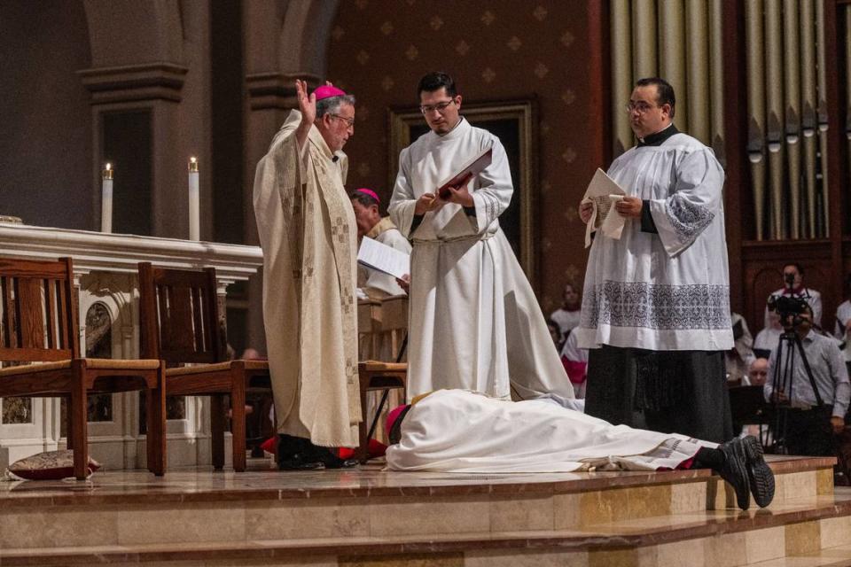 El obispo auxiliar Rey Bersabal se postra ante el altar durante su ceremonia de ordenación del viernes, mientras el obispo de Sacramento Jaime Soto lee una escritura.