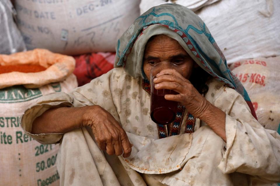 A woman drinks a plum and tamarind drink to cool off (Reuters)