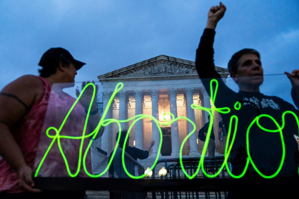 Protesters mark the first anniversary of the Supreme Court's decision overturning Roe v. Wade by displaying a neon sign in support of abortion access on June 23, 2023. State-level abortion bans mean some medical residents have trouble learning how to perform abortions. California is welcoming out-of-state OB-GYN residents.