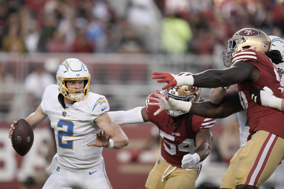 Los Angeles Chargers quarterback Easton Stick (2) is chased by San Francisco 49ers defenders during the first half of a preseason NFL football game Friday, Aug. 25, 2023, in Santa Clara, Calif. (AP Photo/Godofredo A. Vásquez)