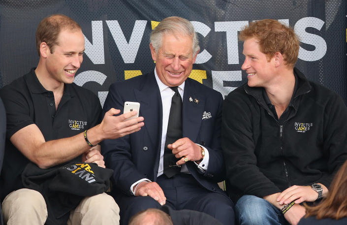 LONDON, ENGLAND - SEPTEMBER 11:  Prince William, Duke of Cambridge, Prince Harry and Prince Charles, Prince of Wales look at a mobile phone as they watch the athletics at Lee Valley Track during the Invictus Games on September 11, 2014 in London, England. The International sports event for &#39;wounded warriors&#39;, presented by Jaguar Land Rover, is just days away with limited last-minute tickets available at www.invictusgames.org  (Photo by Chris Jackson/Getty Images)