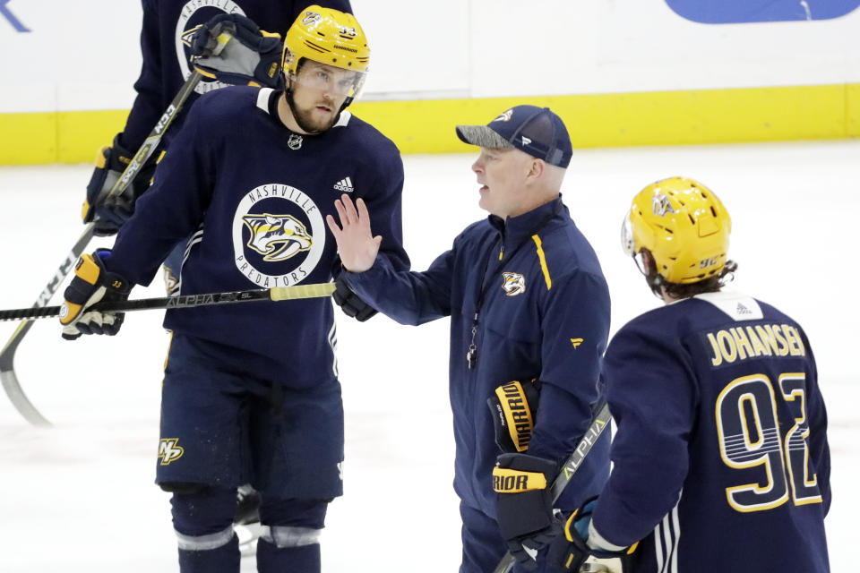 Nashville Predators head coach John Hynes, center, talks with right wing Viktor Arvidsson (33), of Sweden, and center Ryan Johansen (92) during NHL hockey training camp Tuesday, July 14, 2020, in Nashville, Tenn. (AP Photo/Mark Humphrey)