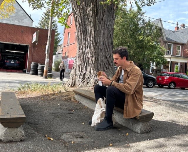 A passerby enjoys lunch under the old elm. Locals say it's a favourite spot to stop and chat.