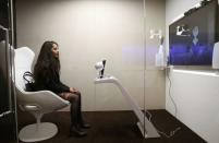 An attendee communicate with SARA, a socially aware robot assisstant, during a presentation at the annual meeting of the World Economic Forum (WEF) in Davos, Switzerland, January 17, 2017. REUTERS/Ruben Sprich