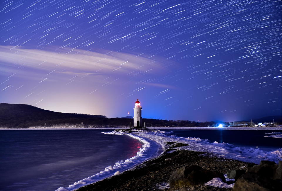 The Geminids meteor shower during its peak, in the night sky over Tokarevsky Lighthouse on Egersheld Cape on Russky Island in the Sea of Japan on December 13, 2017.  / Credit: Yuri Smityuk\TASS via Getty Images