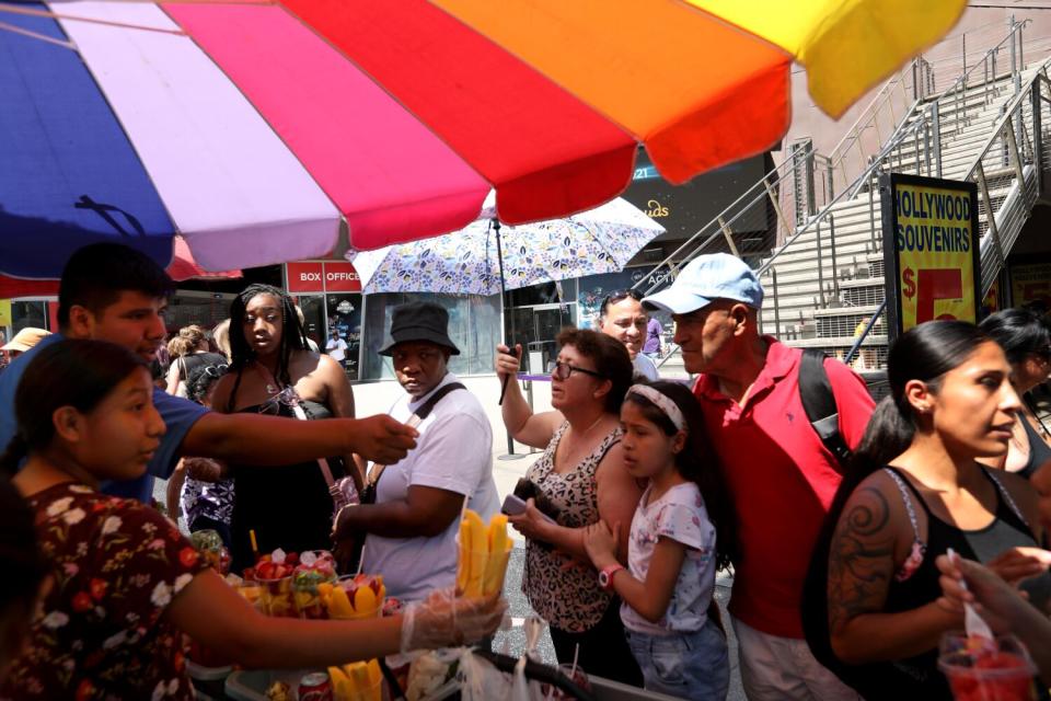 Vendors sell fruit to customers during heatwave.