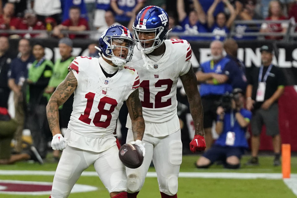 New York Giants tight end Darren Waller (12) celebrates with wide receiver Isaiah Hodgins (18) after Hodgins caught a pass for a touchdown against the Arizona Cardinals during the second half of an NFL football game, Sunday, Sept. 17, 2023, in Glendale, Ariz. (AP Photo/Ross D. Franklin)