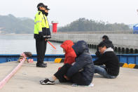 Relatives of passengers aboard the sunken Sewol ferry wait for their missing loved ones at a port in Jindo, South Korea, Tuesday, April 22, 2014. As divers continue to search the interior of the sunken ferry, the number of confirmed deaths has risen, with about 220 other people still missing. (AP Photo/Ahn Young-joon)