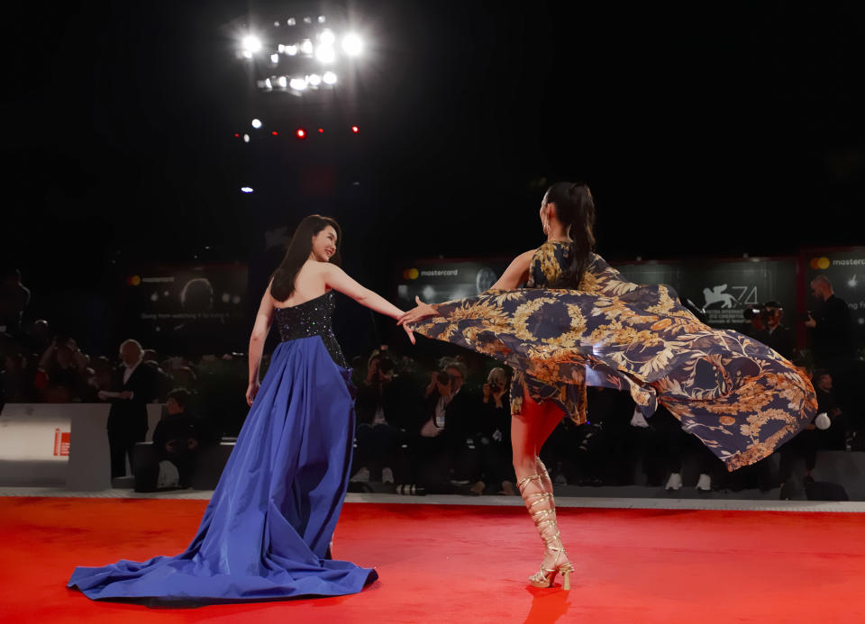 File - Actresses Qi Wei, left, and Tao Okamoto pose for photographers at the premiere for the film "Zhuibu" (Manhunt) at the Venice Film Festival. The 77th Venice Film Festival will kick off on Wednesday, Sept. 2, 2020, but this year's edition will be unlike any others. Coronavirus restrictions will mean fewer Hollywood stars, no crowds interacting with actors and other virus safeguards will be deployed. (AP Photo/Domenico Stinellis, File)