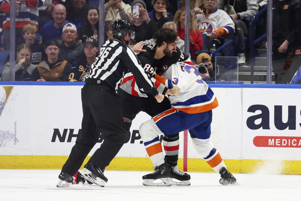 Linesman David Brisebois (96) breaks up a fight between Buffalo Sabres right wing Alex Tuch (89) and New York Islanders defenseman Adam Pelech (3) during the second period of an NHL hockey game Saturday, Oct. 21, 2023, in Buffalo, N.Y. (AP Photo/Jeffrey T. Barnes)