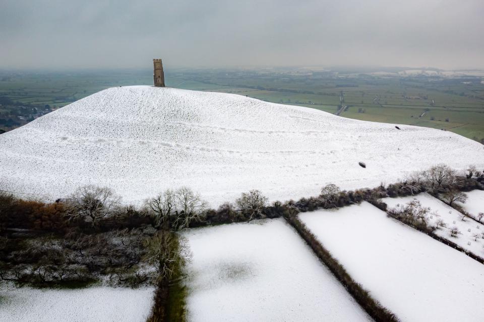 Snow settles on Glastonbury Tor (PA)