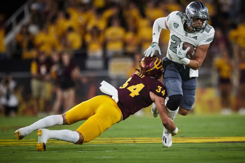 Eastern Michigan Eagles running back Samson Evans (22) runs the ball as Arizona State Sun Devils linebacker Kyle Soelle (34) lunges for a tackle at Sun Devil Stadium in Tempe.