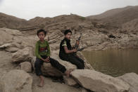 In this July 30, 2018, photo, a 17 year-old boy holds his weapon in High dam in Marib, Yemen. Experts say child soldiers are “the firewood” in the inferno of Yemen’s civil war, trained to fight, kill and die on the front lines. Though both sides in the war recruit children, the Houthi rebels rely on them the most. One Houthi military official said 18,00 children had been recruited over the past four years. (AP Photo/Nariman El-Mofty)