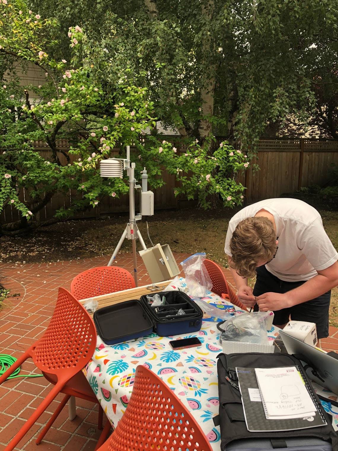 PNNL data scientist Sam Rosenberg inspects scientific equipment outside a home in Portland, Ore., when wildfires drove air quality levels to particularly unhealthy levels in 2020.