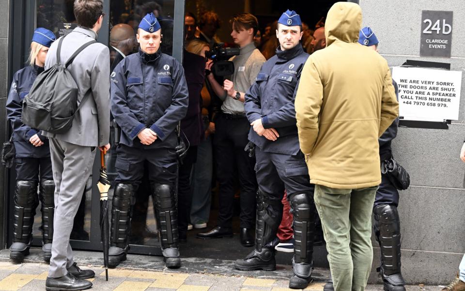 Police officers stand on the door not allowing ticket holders entry