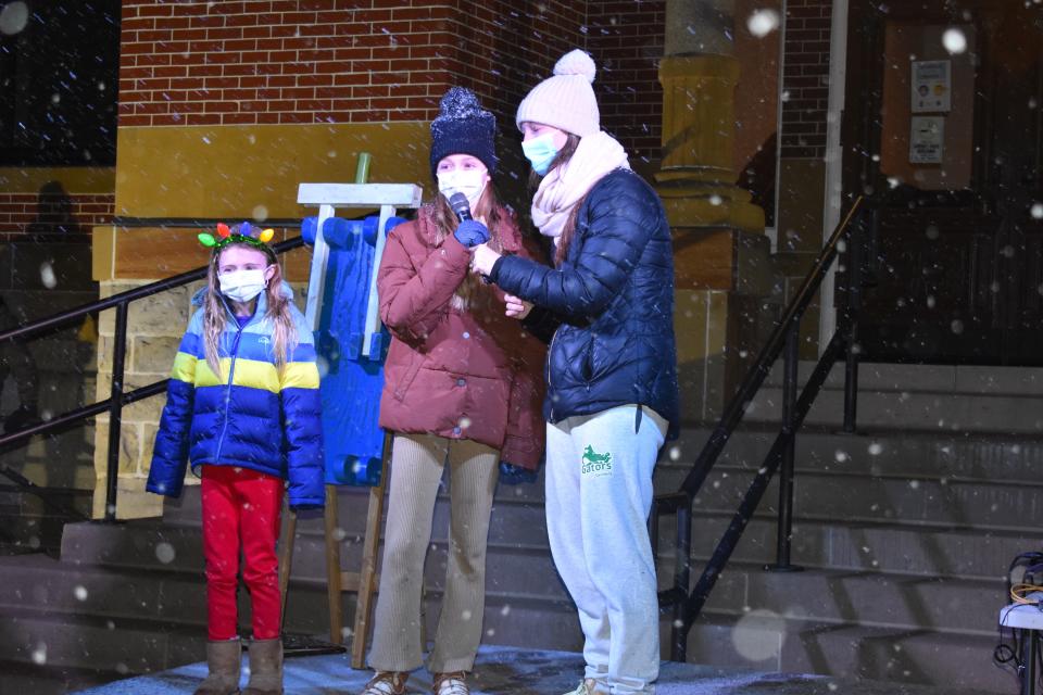 Julie Adams, right, the daughter of former Adrian Mayor Jim Berryman, and her daughters, Bernadette, 7, left, and Violet, 10, count down Monday evening to the lighting of the community Christmas tree in Adrian on the grounds of the old Lenawee County Courthouse. Berryman flipped the switch and lighted the tree for the holiday season.