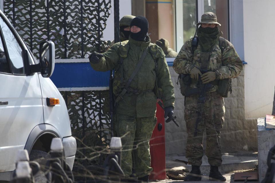 Pro-Russian soldiers check the traffic entering the Ukrainian navy headquarters, after taking control Wednesday, in Sevastopol, Crimea, on Thursday, March 20, 2014. Pro-Russian forces seized three Ukrainian warships Thursday and Ukraine said its troops were being threatened in Crimea as the U.S. announced a new round of sanctions against Russia for its annexation of the Black Sea peninsula. (AP Photo/Ivan Sekretarev)