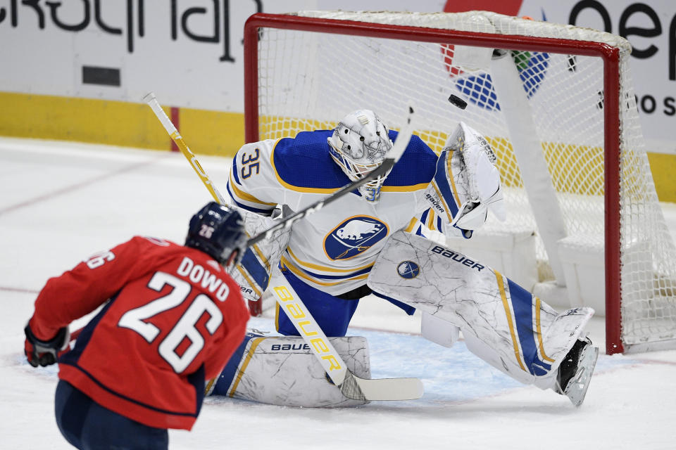 Washington Capitals center Nic Dowd (26) shoots the puck that went over the net against Buffalo Sabres goaltender Linus Ullmark (35) during the second period of an NHL hockey game, Sunday, Jan. 24, 2021, in Washington. (AP Photo/Nick Wass)