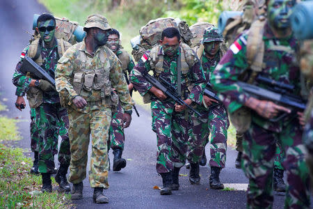 Australian Army soldier Sergeant Francis Jakis (L) is pictured with Indonesian Army soldiers during the Junior Officer Combat Instructor Training course conducted by the Australian Army's Combat Training Centre in Tully, Australia, October 10, 2014. Australian Defence Force/Handout via REUTERS