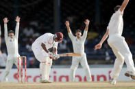 West Indies bowler Kemar Roach (R) celebrates the wicket of Australian batsman Ben Hilfenhausdur (L) during the second day of the second-of-three Test matches between Australia and West Indies April 16, 2012 at Queen's Park Oval in Port of Spain, Trinidad. AFP PHOTO/Stan HONDA