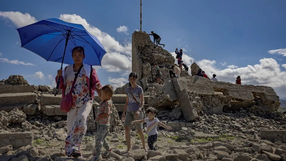 Some visitors brave the extreme heat to see the dam, where parts of damaged structures still stand. - Ezra Acayan/Getty Images